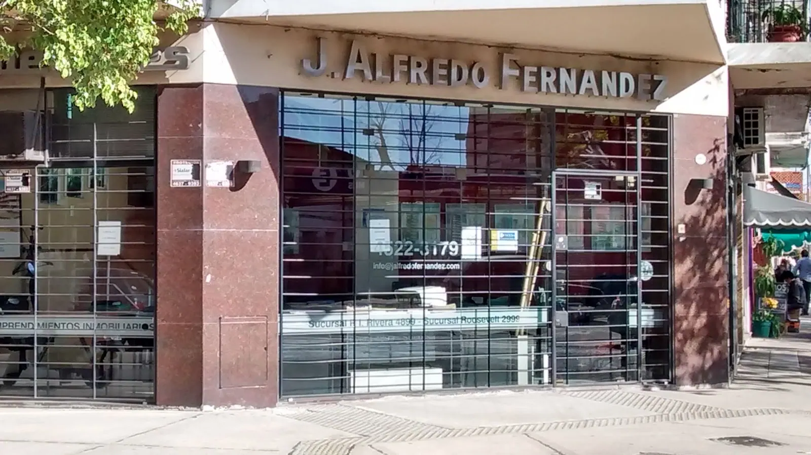 La oficina de Monroe 5402 en la esquina: vidriera de granito y vidrio con J. Alfredo Fernández en letras de acero